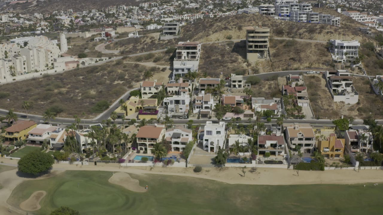 Hillside residential blocks and golf course seen from above.