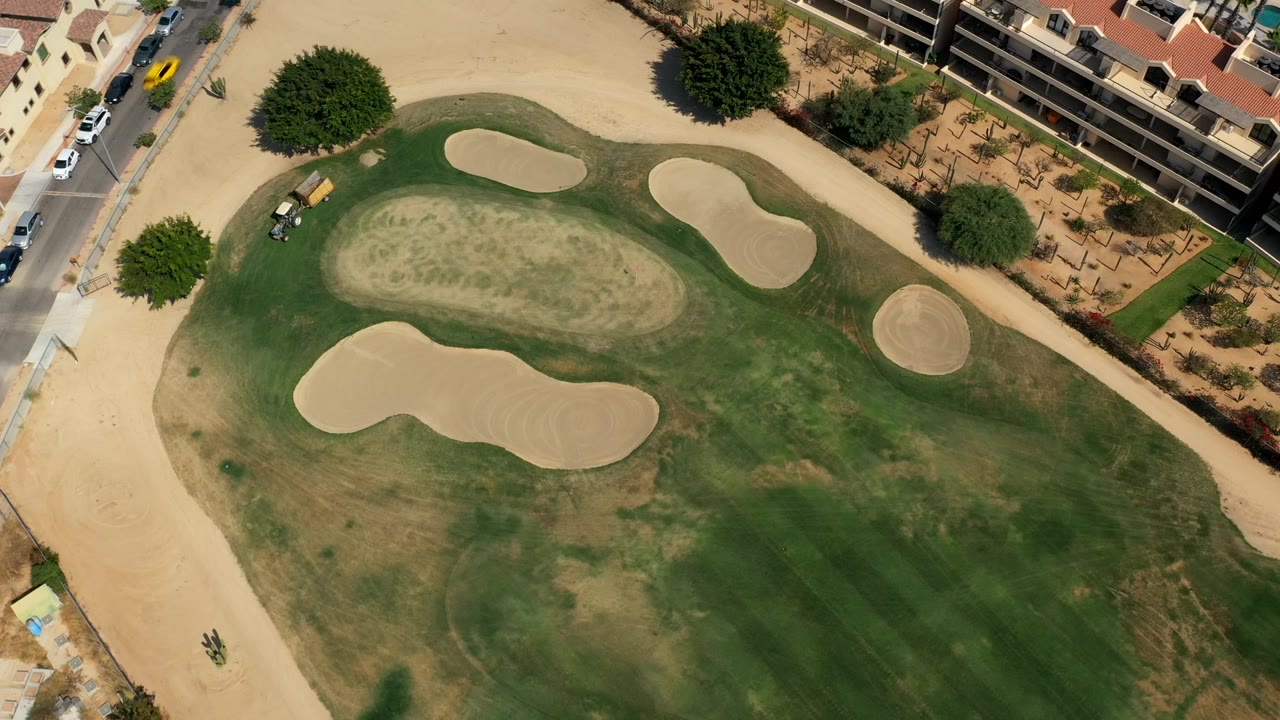 Overhead golf course with sand bunkers and resort buildings