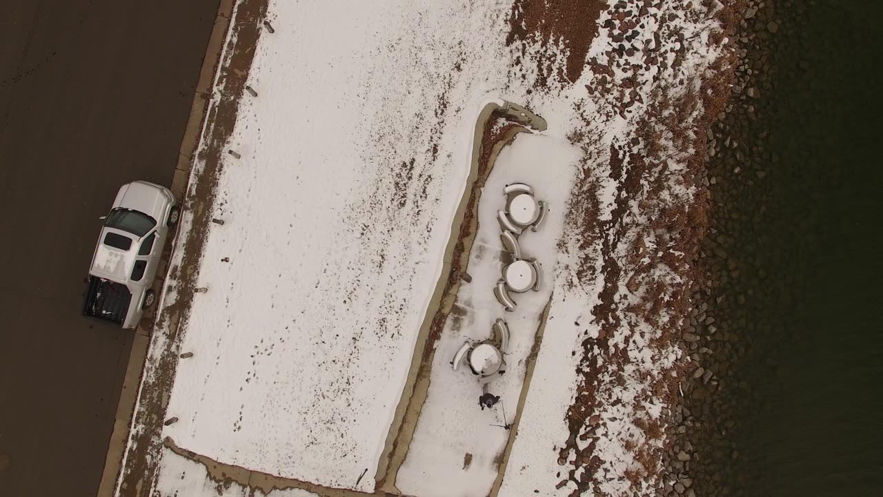 Top-down shot of a snowy grassy median next to a road and pickup.