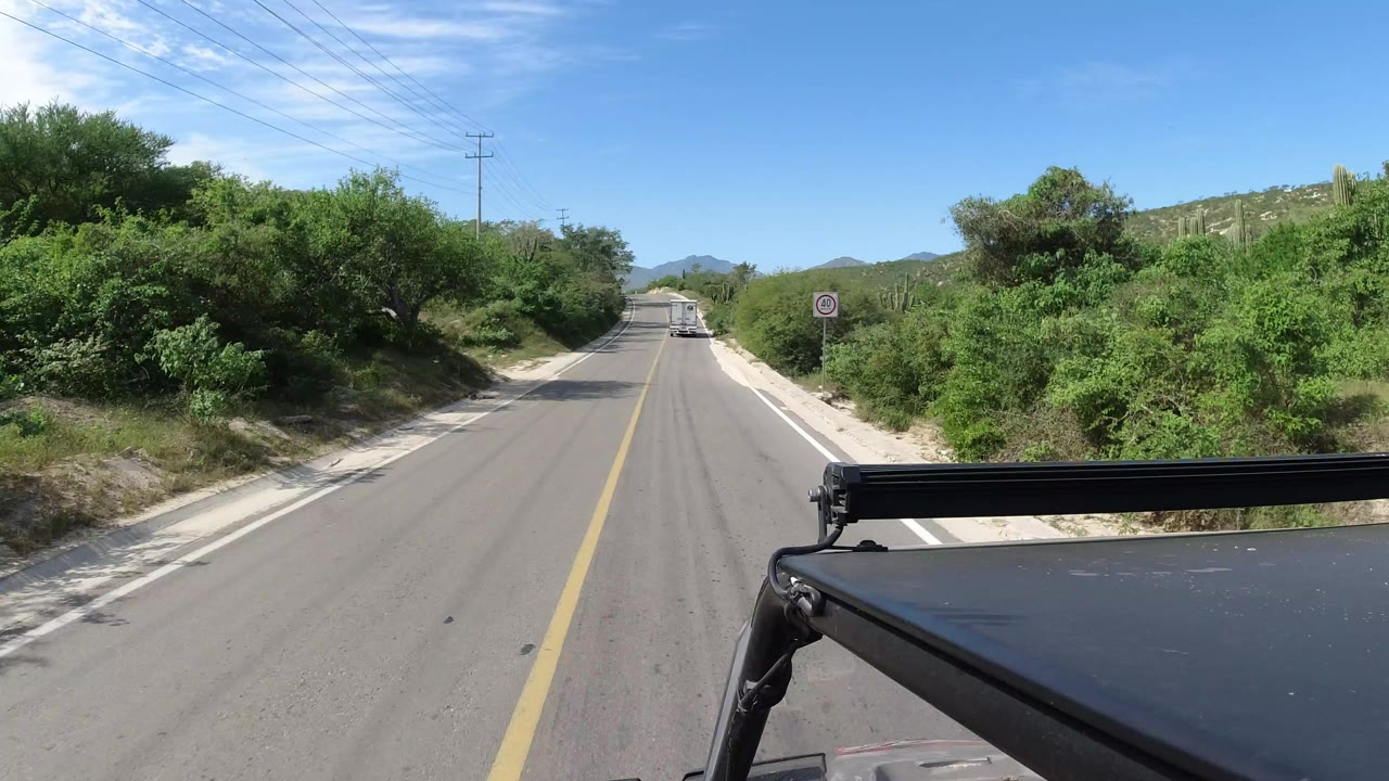 Forward road view from a jeep roof on a sunny rural road