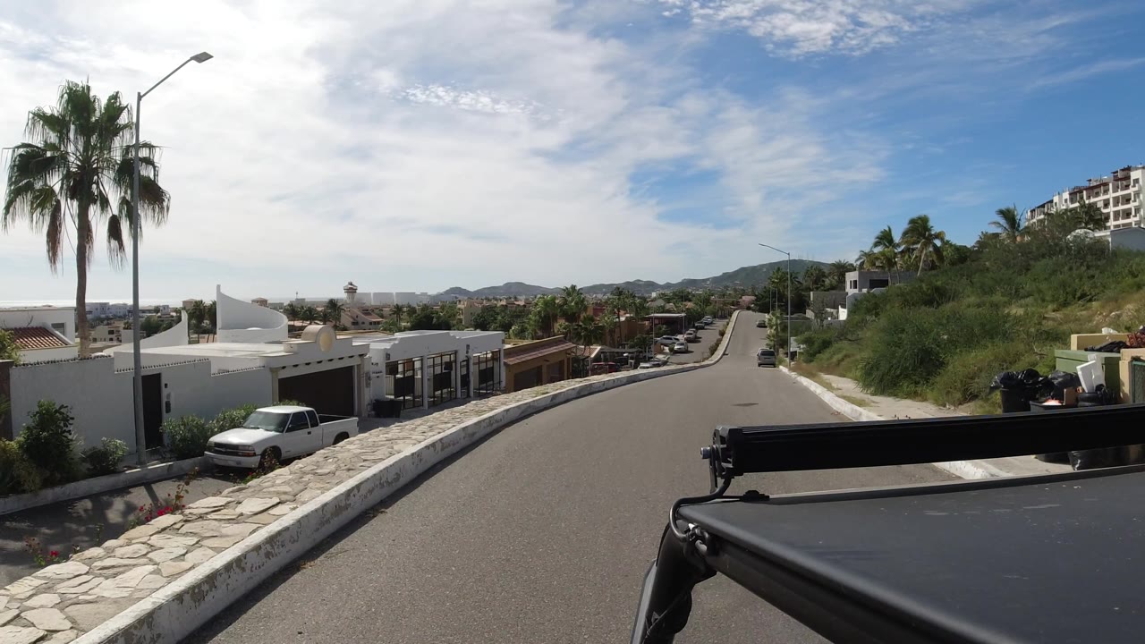 Road curving past hillside homes and greenery