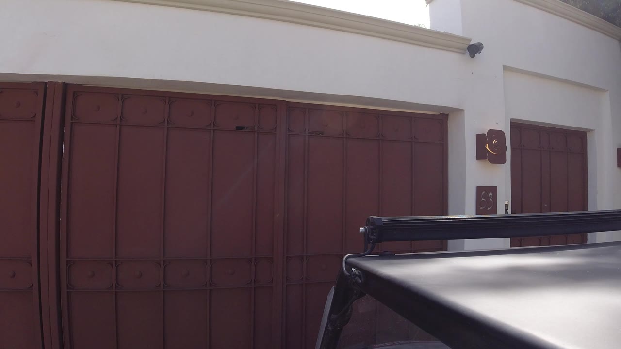 White building facade with red metal doors and dark foreground awning.