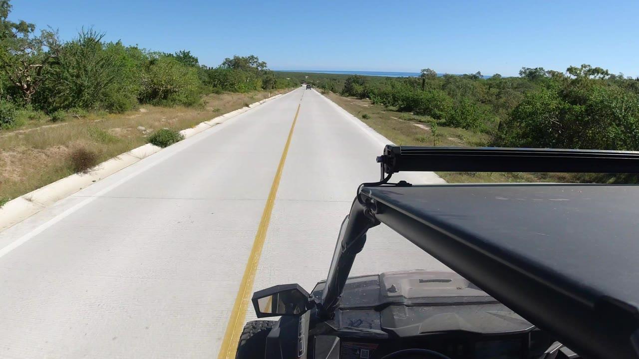 Empty paved road ahead with Jeep frame in the foreground
