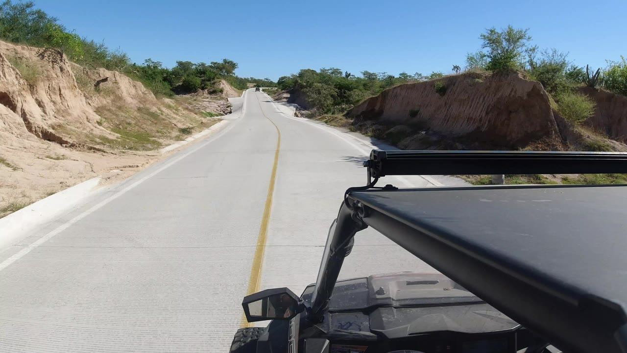 Concrete road ahead from a black open vehicle