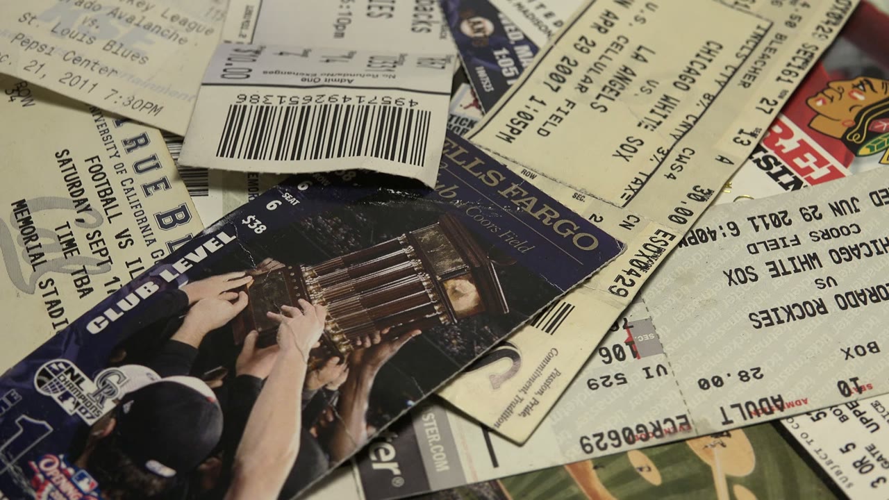 Overlapping printed tickets and passes with barcodes and seat text.