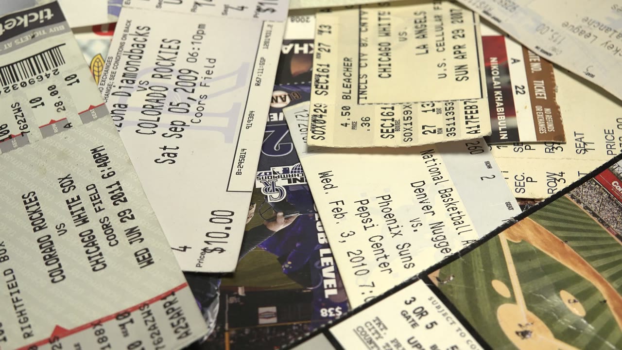Overlapping sports tickets on a rotating circular tabletop.