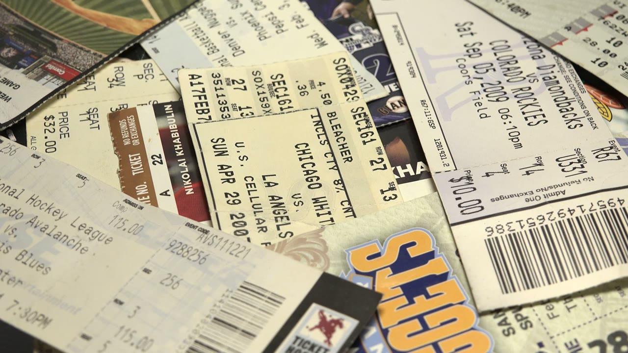 The ticket pile has rotated, showing more angled stubs, barcode blocks, and partial team and vendor marks with no visible people.