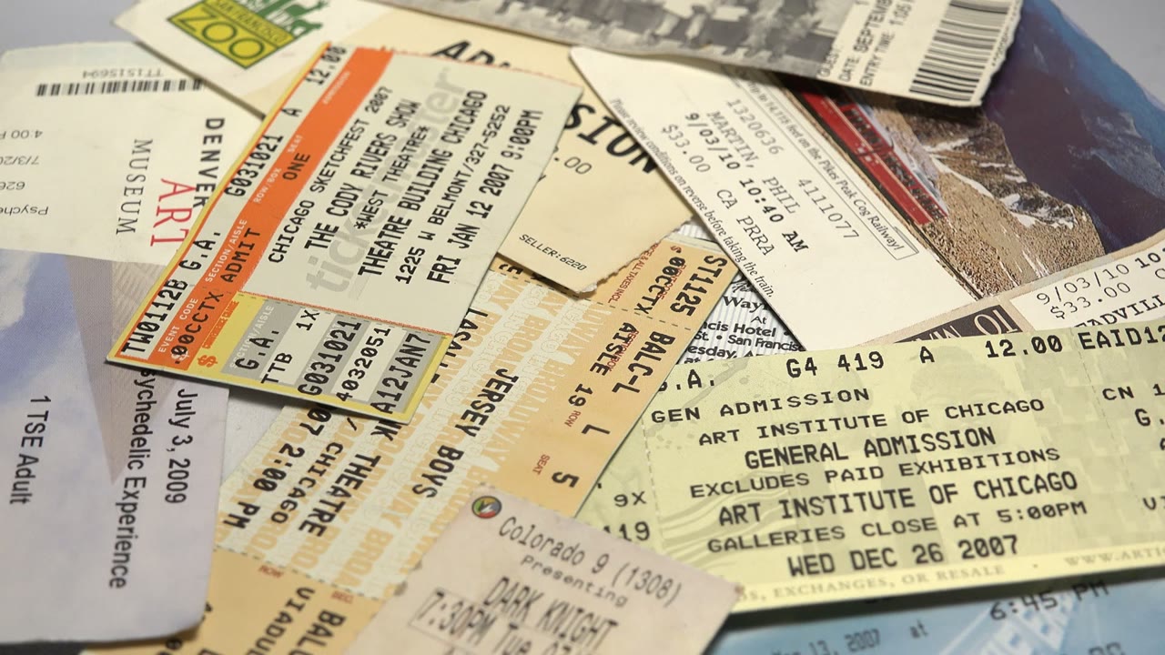 A dense spread of overlapping admission tickets, barcodes, dates, and venue text fills the frame, with no visible people.