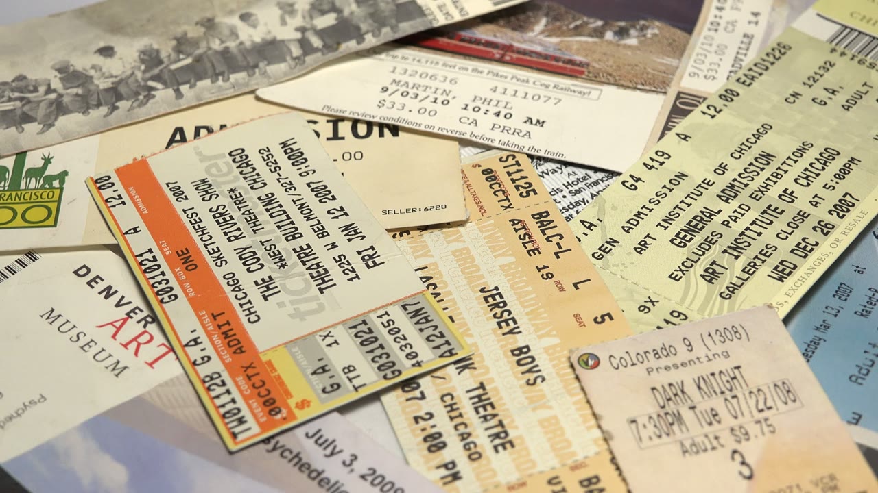 A spread of admission tickets includes a green zoo mark, theater stubs, barcodes, and date stamps across overlapping paper, with no visible people.