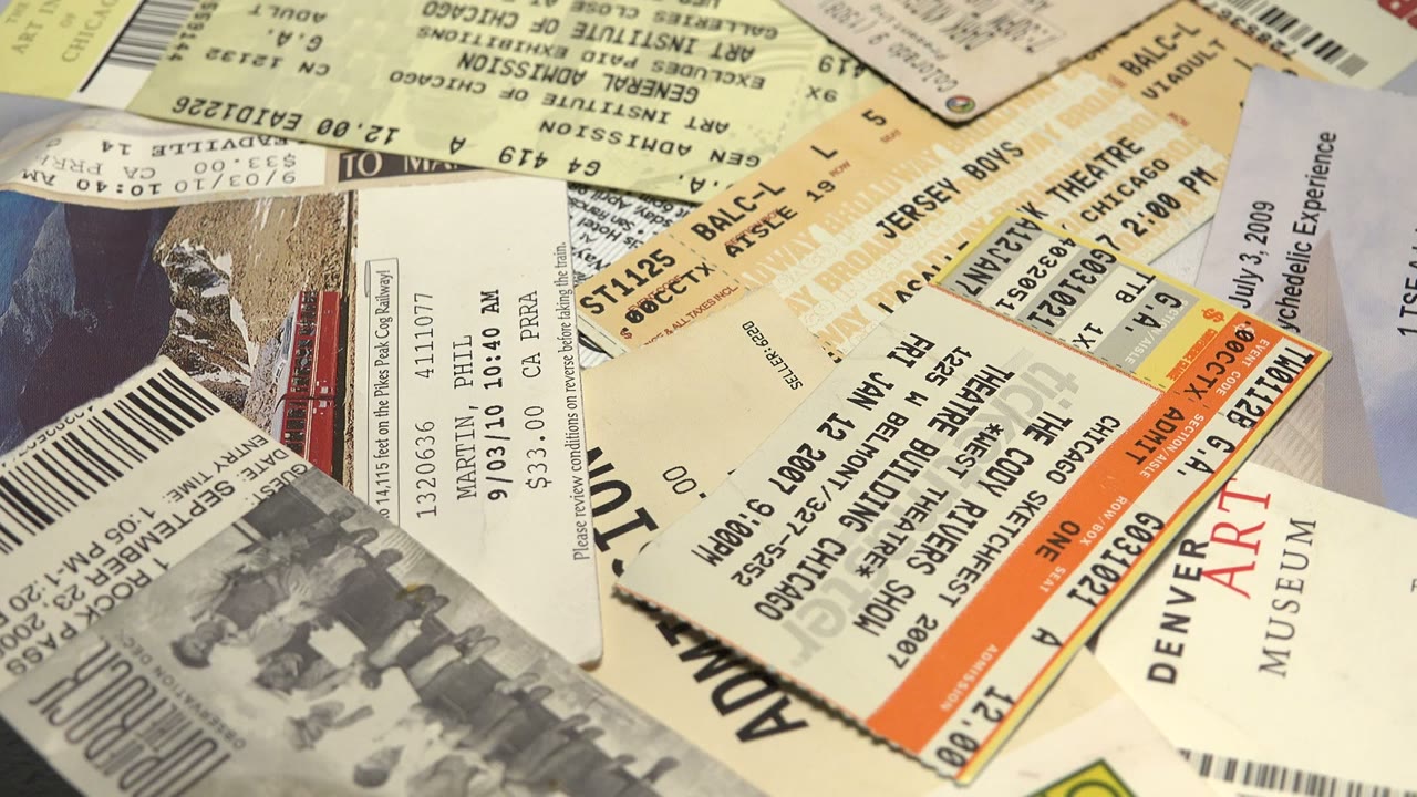 A closer section of the ticket pile shows Denver Art Museum text, theater admission details, barcodes, and layered paper edges with no visible live people.