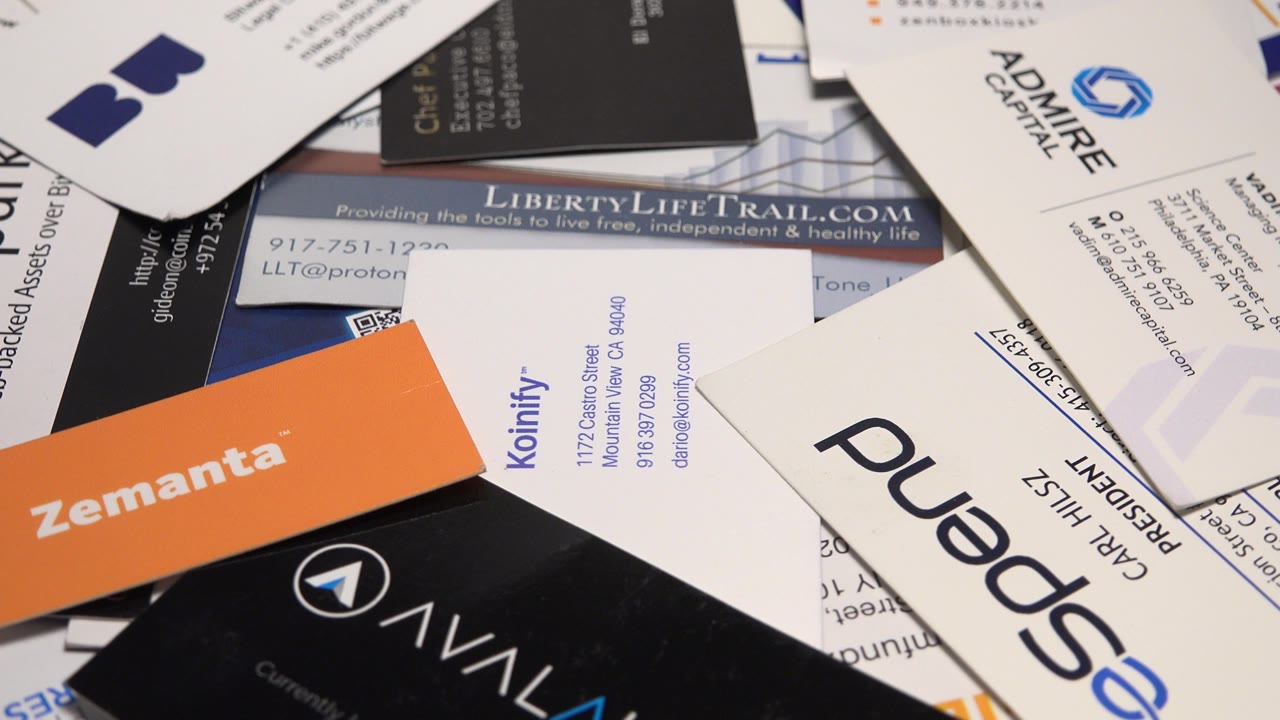 Overlapping business cards spread across a table.