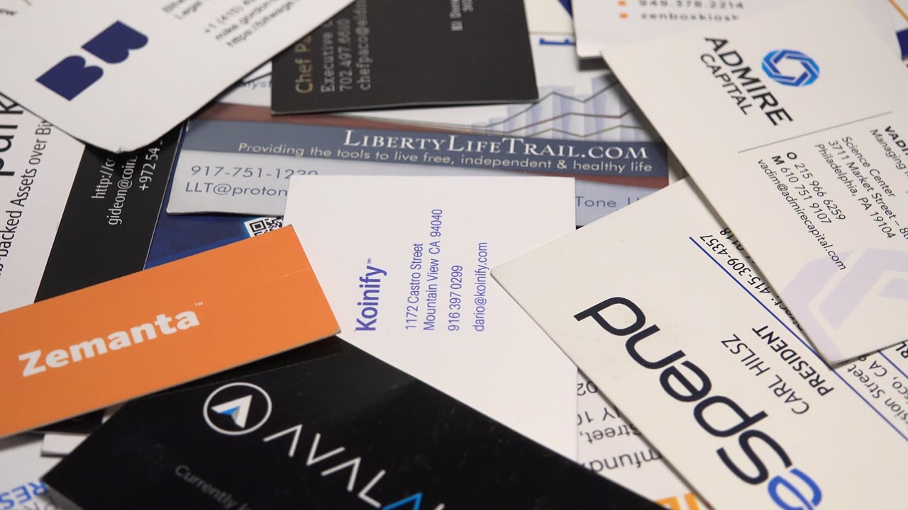 A Zemanta orange card, black Avilaunch card, and several white cards sit layered over other printed business cards, with no visible people.