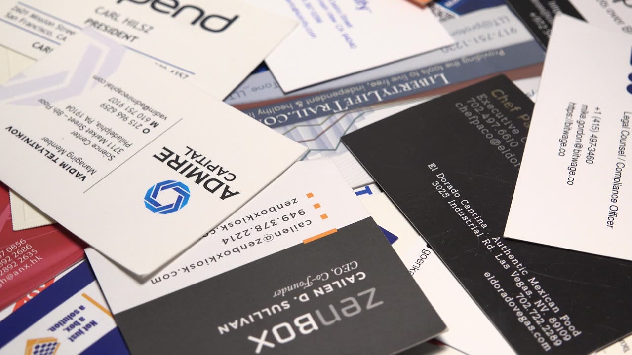 Promotional cards and business cards spread across a surface.