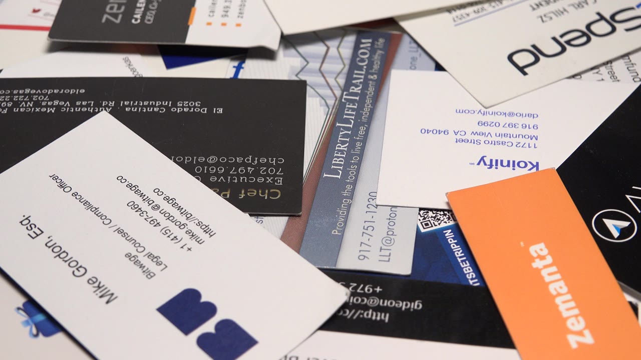 Business cards with a white card centered over darker cards.
