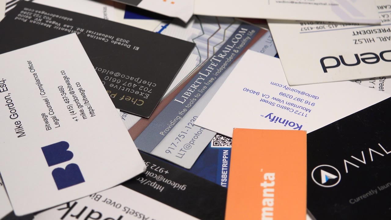 The card pile shifts in framing to show an orange Zemanta card and black business cards more prominently among white cards, with no visible people.