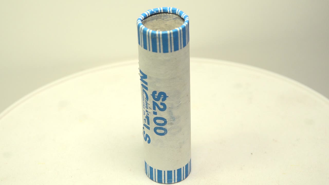 The nickel roll remains upright on the white turntable as the wrapper turns to show the blue $2.00 marking, with no visible people.