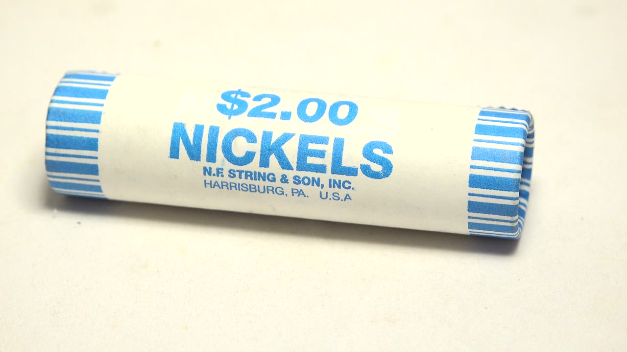 A white cardboard roll labeled "$2.00 NICKELS" lies diagonally on a pale surface with blue striped ends and no visible people.