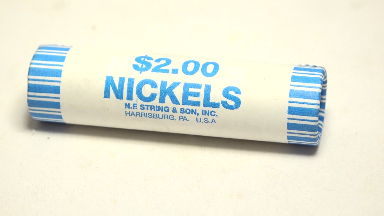 The nickel tube remains horizontal in close-up, with the blue "$2.00 NICKELS" label centered and no visible people.