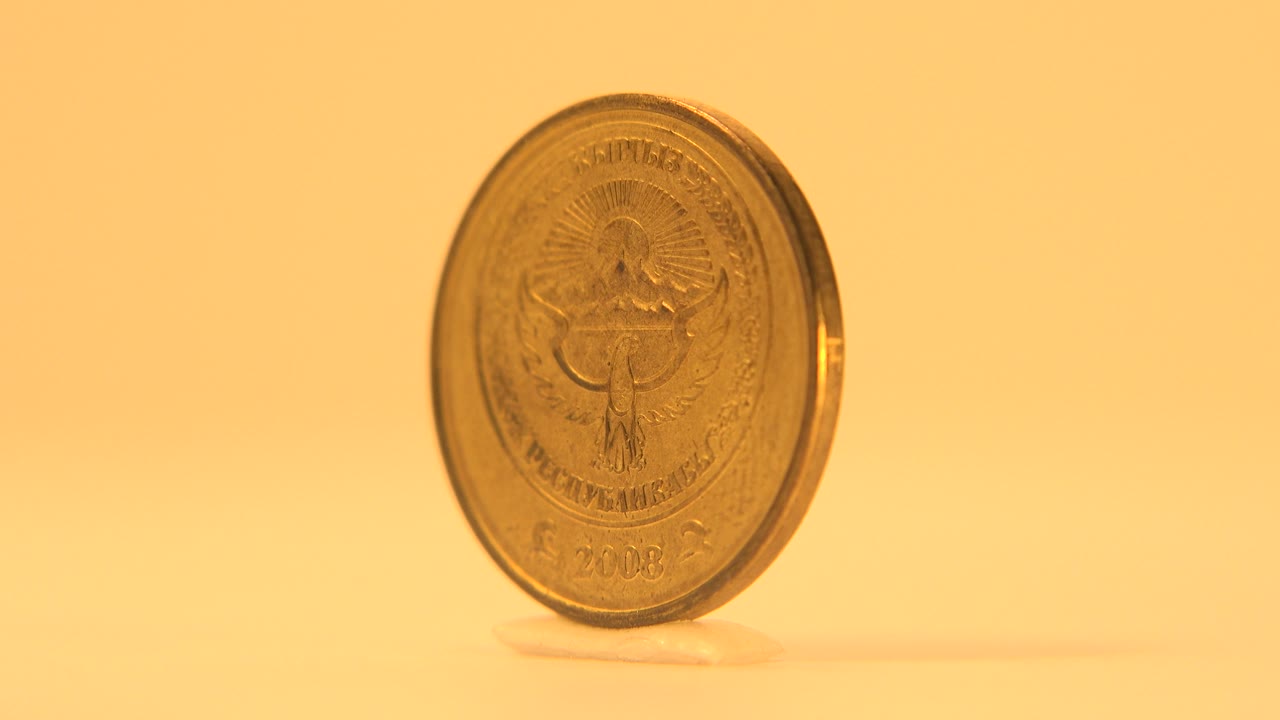 Upright coin still showing the emblem side.