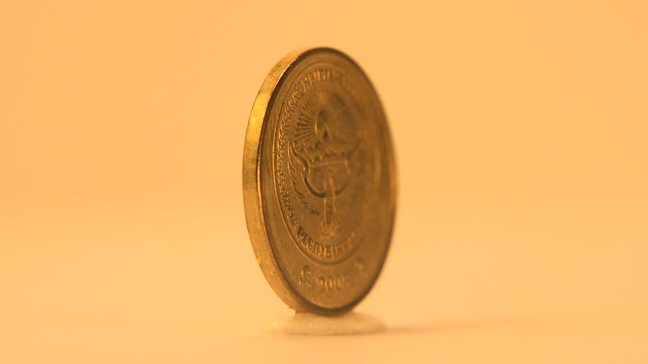 Reverse side of a standing coin partly turned toward camera