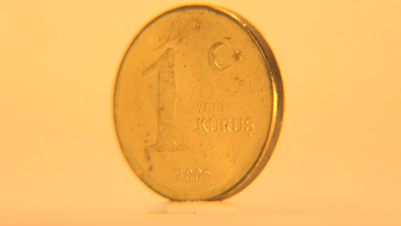 Close front view of a gold-colored 1 Yeni Kurus coin.