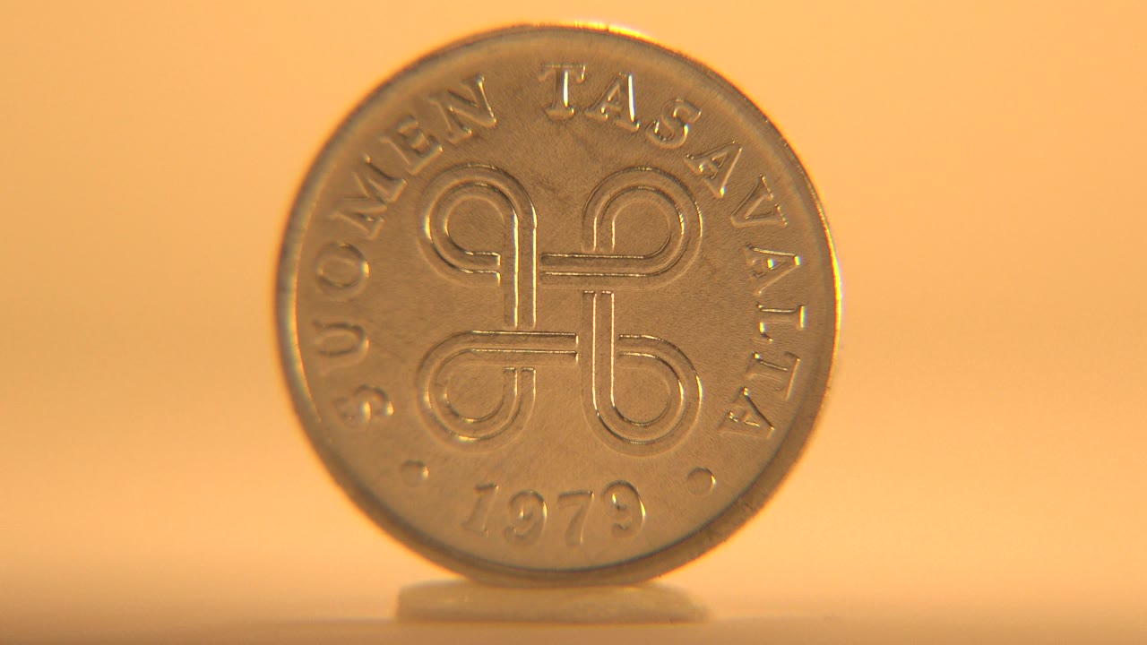 Front face of a 1979 Suomen Tasavalta coin standing upright on a flat surface against a warm orange background, with no visible people.