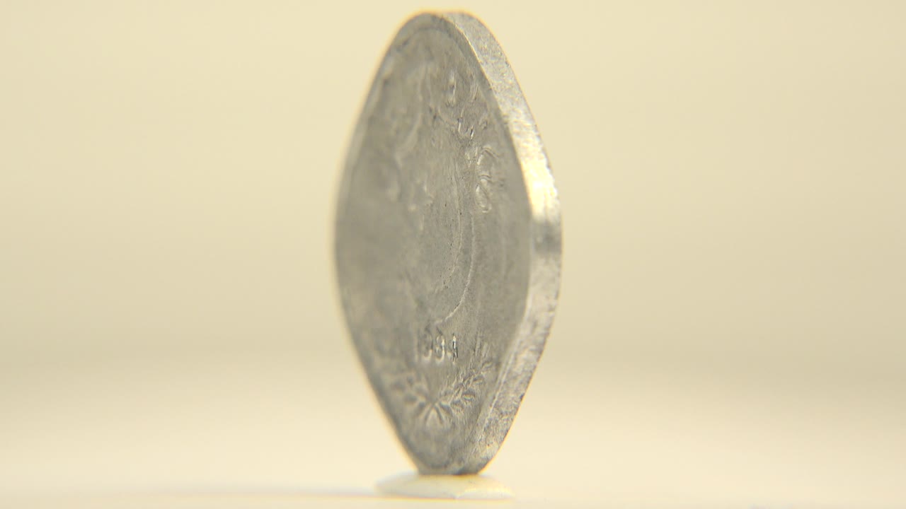 Thin edge view of the upright silver coin.