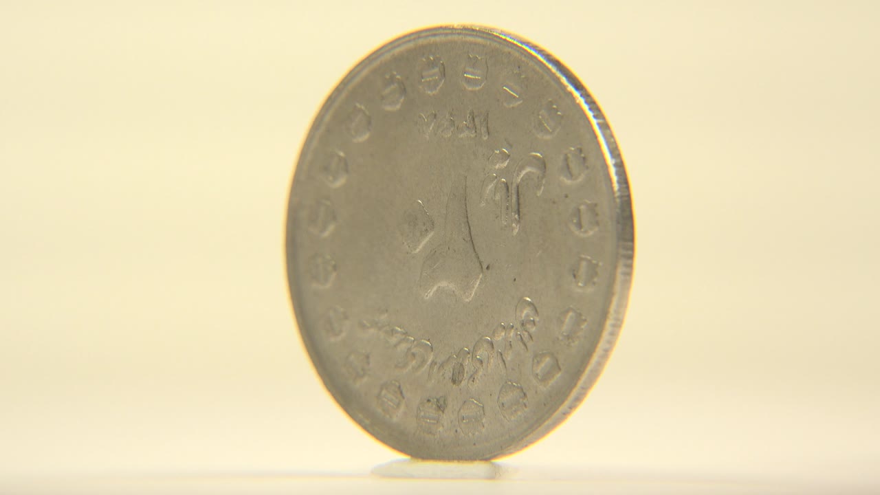 A close view of the coin face fills more of the left side of the frame, with soft highlights across the metal and no visible people.