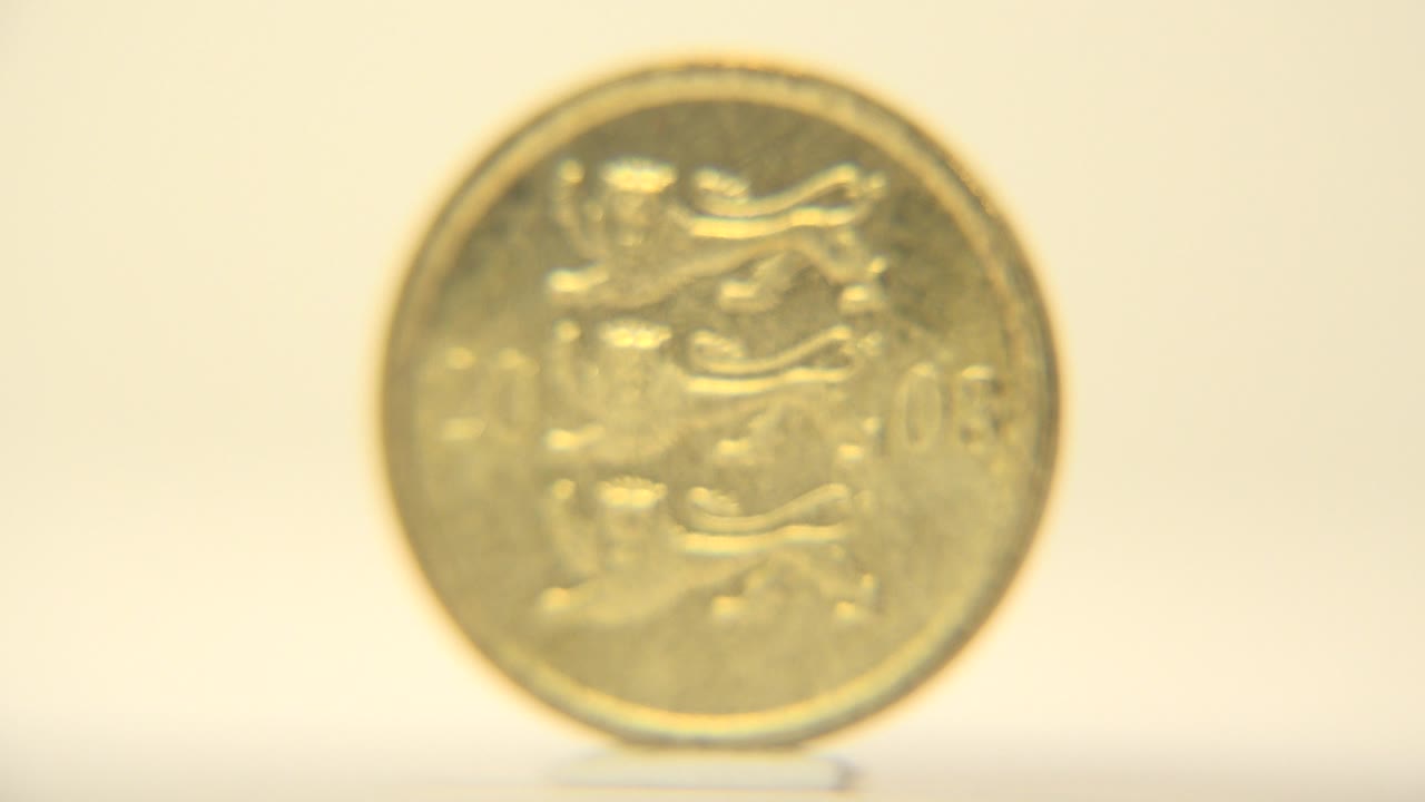 The front face of a brass-toned Estonian ten-cent coin fills the center of the frame on a pale surface, softly lit with no visible people.