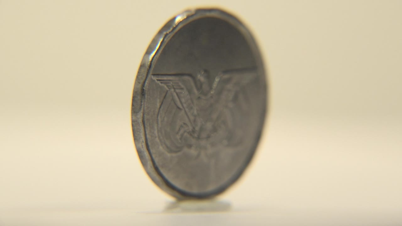 Coin angled toward the camera with emblem side partly visible.