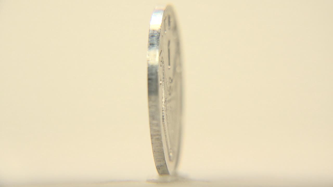Thin edge of a silver coin in profile