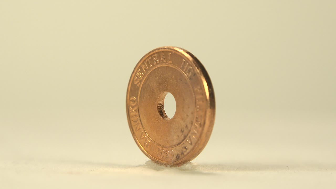 Coin turned partly sideways while balanced on edge