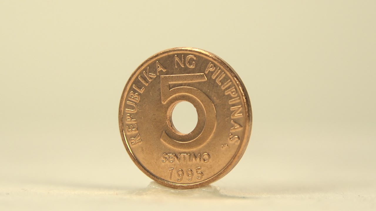 A centered view shows the copper coin front with the circular center hole, 5 denomination, and warm highlights on the raised rim, with no visible people.