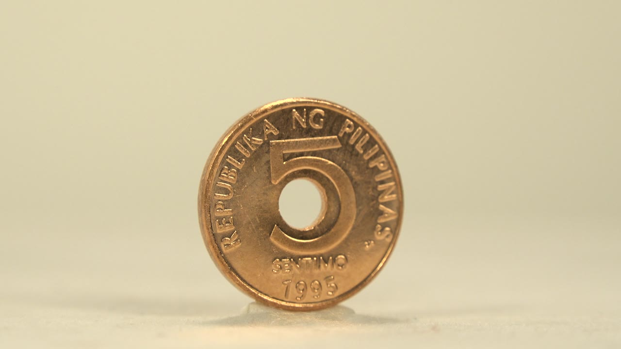 Centered front view of the Philippine five centavo coin, with the raised number and rim text visible in warm indoor-looking light and no visible people.