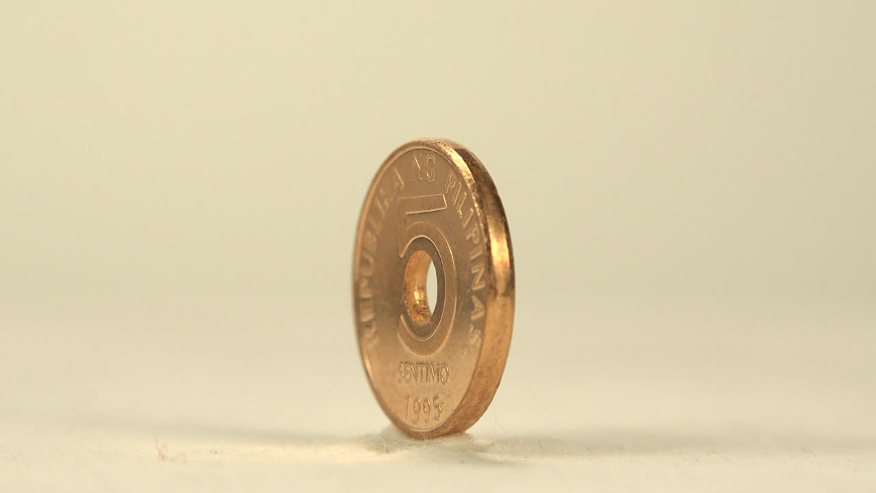 Angled view of the Philippine five centavo coin showing part of the front face and the copper-toned edge, with no visible people.