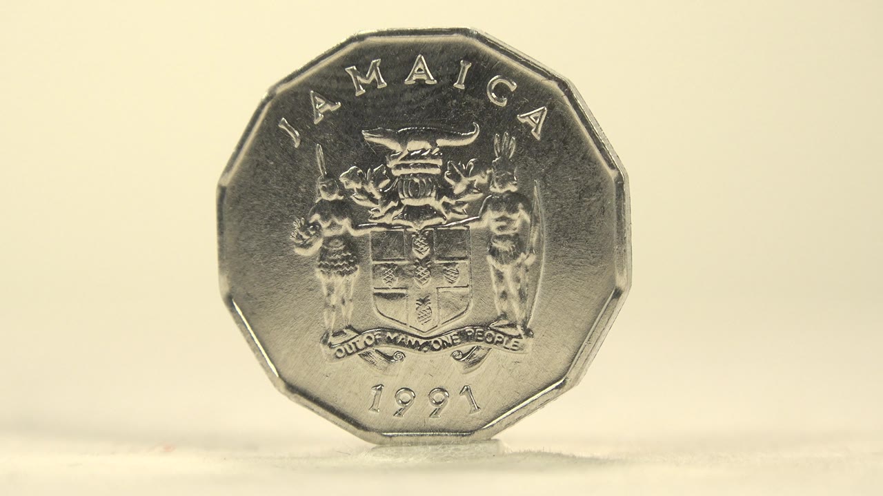 Close front view of the Jamaican coin on a pale surface.