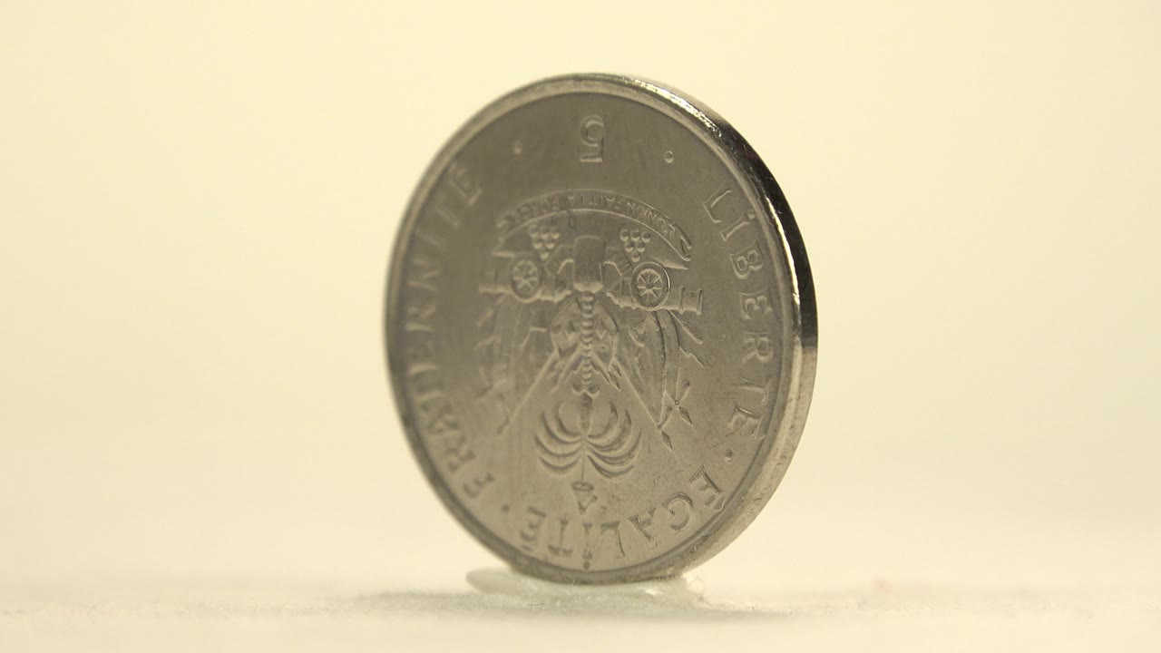 Silver coin turned partly sideways on a display surface