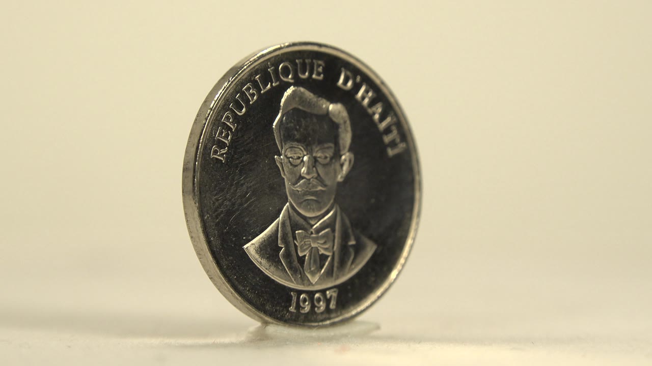 Silver coin remains upright with the portrait side facing camera.