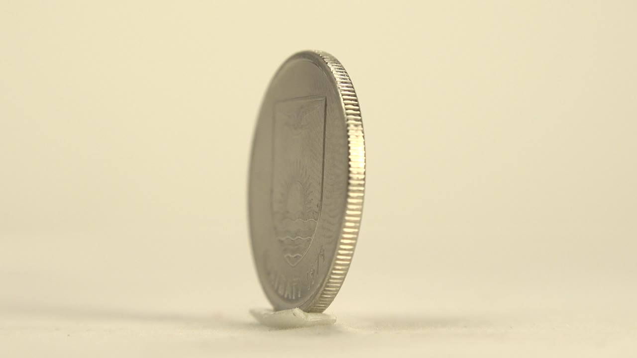 Thin edge view of a standing silver coin