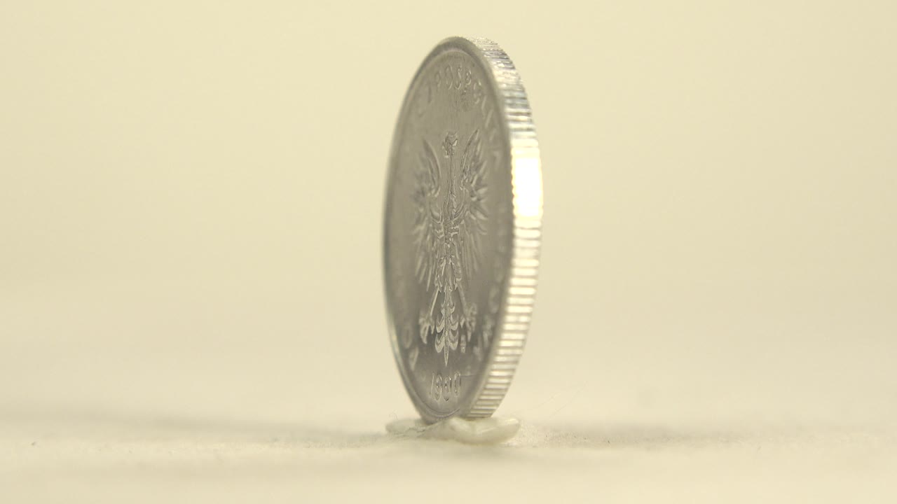 Thin edge view of a spinning silver coin