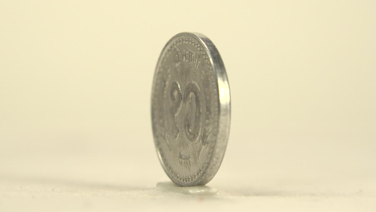 Upright silver coin with front face partly visible