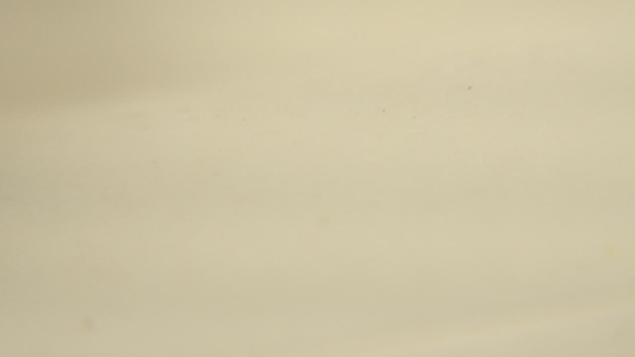The third frame holds a blurred yellow spot low in the frame against a plain cream surface, with no visible people.