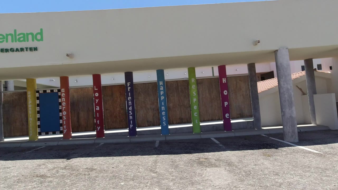 Greenland Kindergarten facade with colored columns and empty pavement.