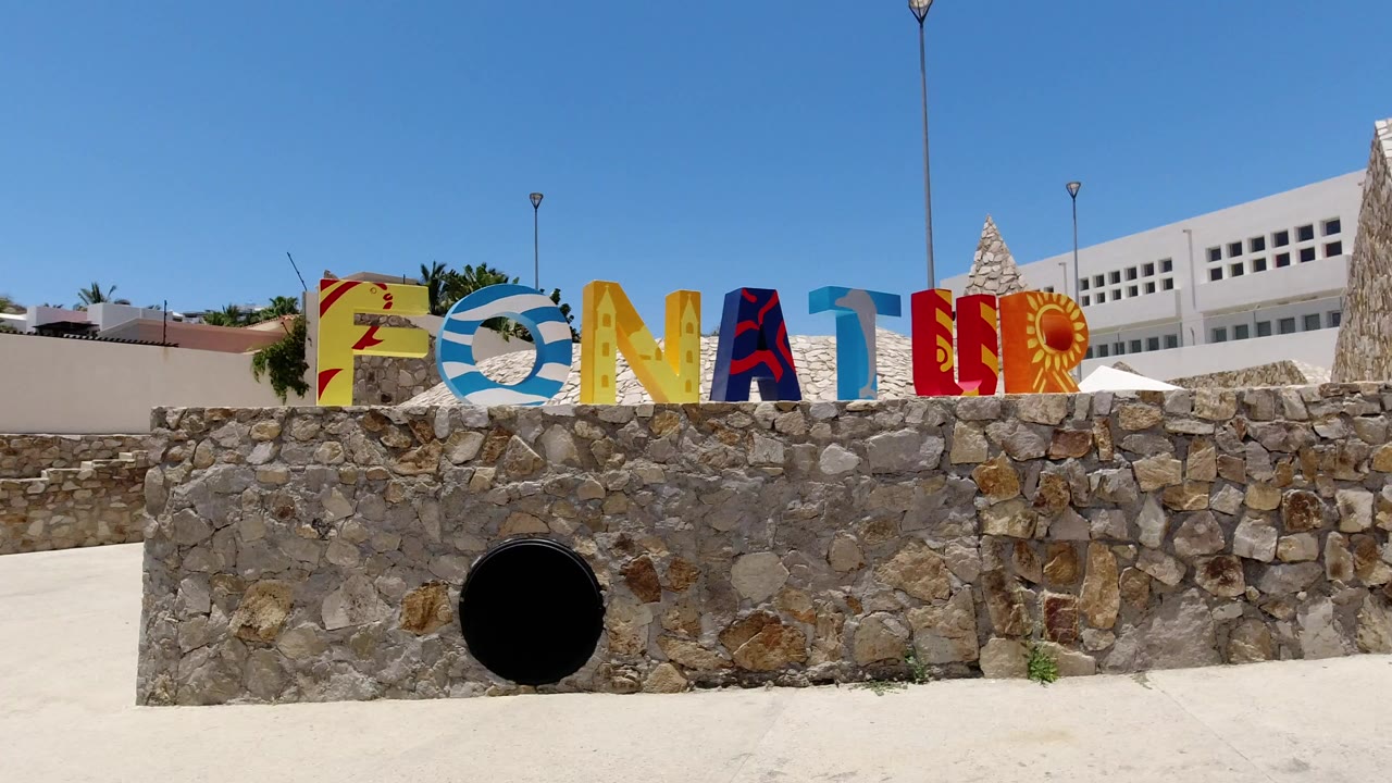 Colorful FONATUR letters on a stone wall under blue sky.