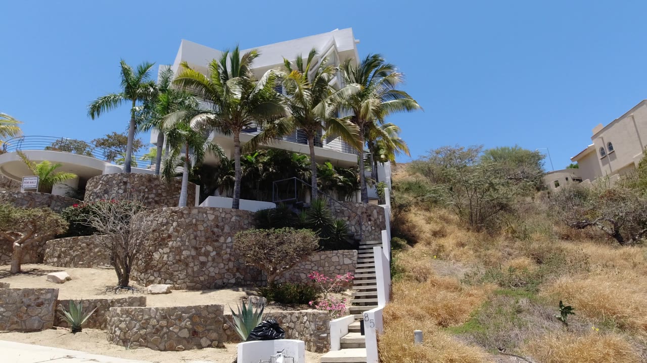 Second frame shows the San Jose del Cabo resort exterior with a curved balcony on the left, palms around the building, stone walls, stairs, and no visible people.