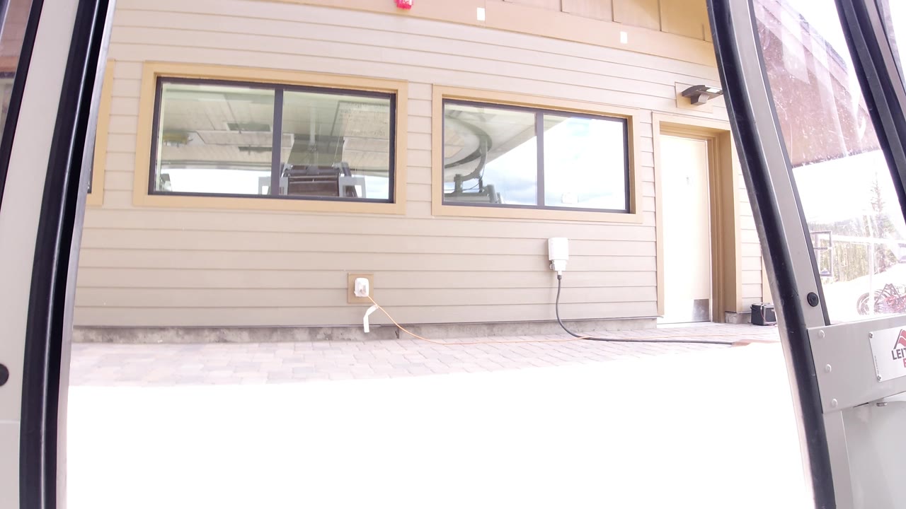 Bright doorway view with building windows and exterior wall equipment