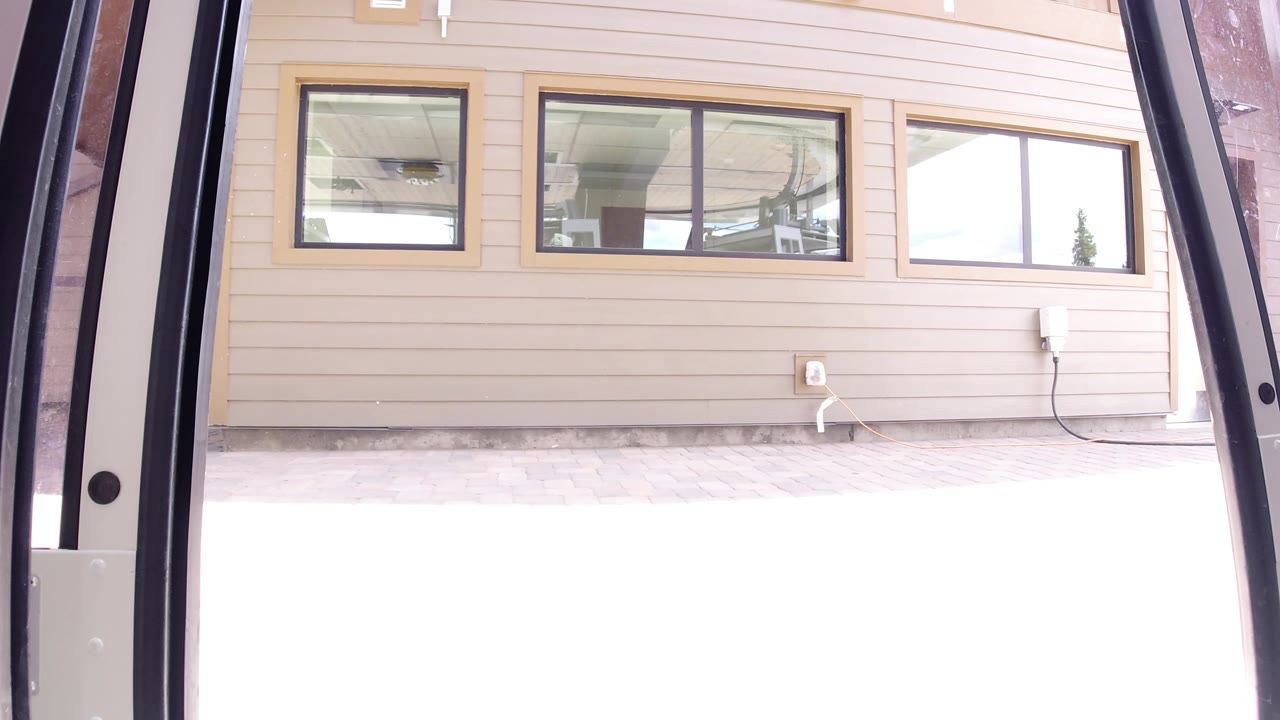 The Winter Park public building remains centered, showing rectangular windows, beige horizontal siding, a wall outlet, dark foreground edges, and no visible people.