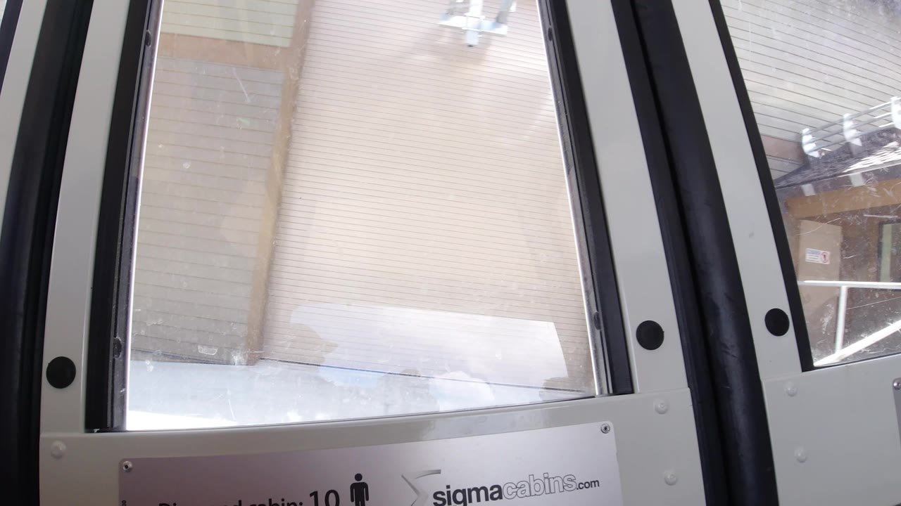 Interior cabin windows facing a snowy platform and building exterior.