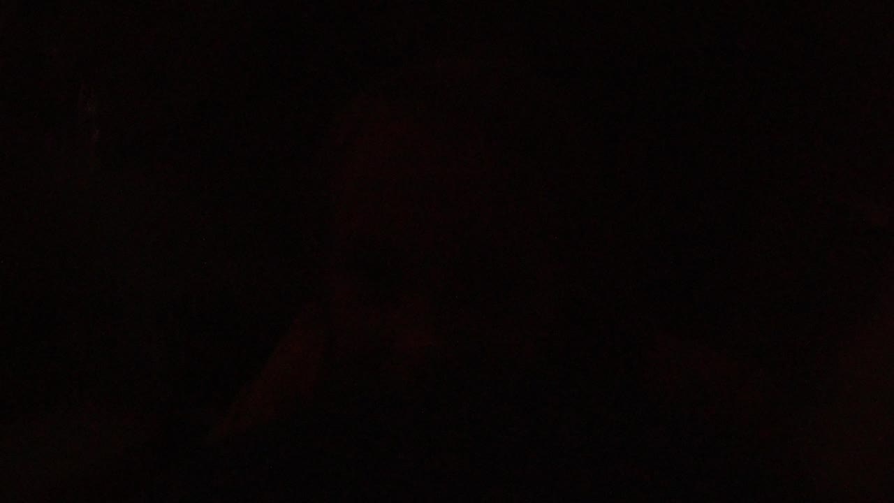 Low-light Winter Park, Colorado interior with a small window and horizontal blinds glowing warm red-orange on the left side of the frame.
