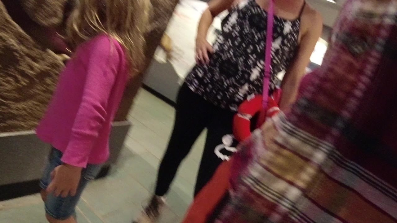 Child and adults near a museum relic display.